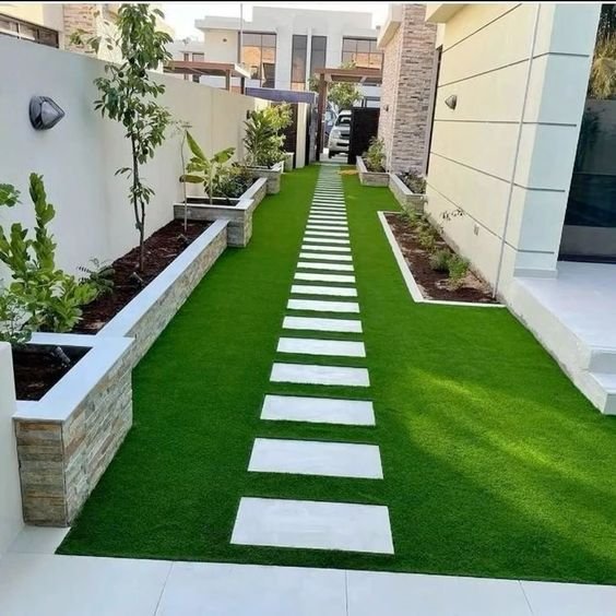 مدخل فيلا فاخر مع تنسيق نباتي وإضاءة جذابة

