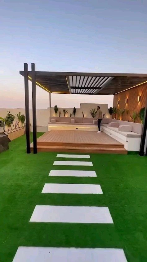 تنسيق حديقة منزلية مع نجيل صناعي وجلسات خشبية

